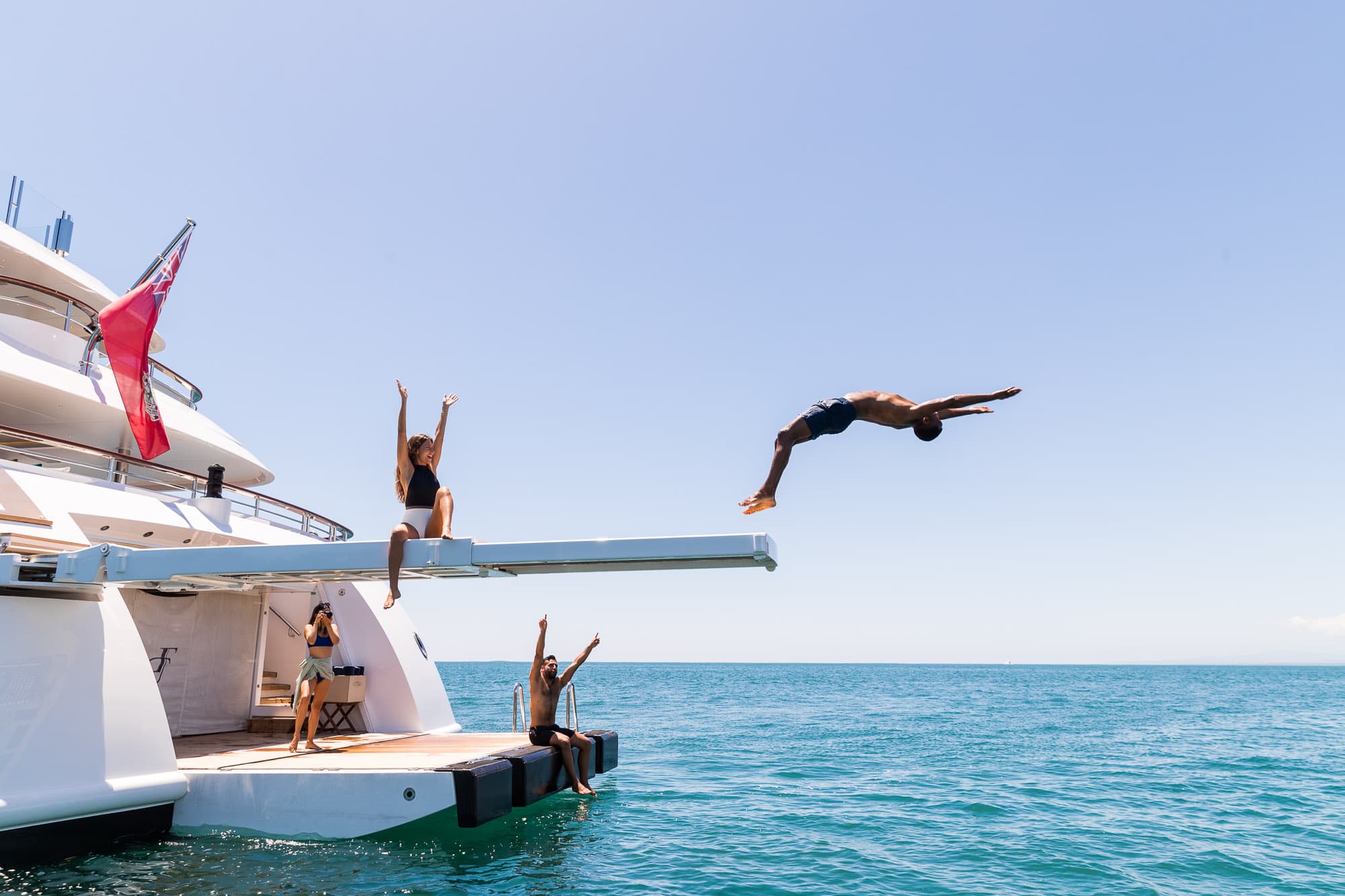 A motor yacht moored beside a stately waterfront estate